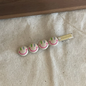 Pince à cheveux colorée en métal avec quatre charms souriants et gravure faite à la main