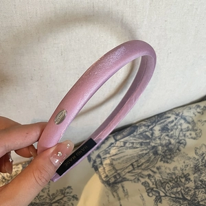 Pale purple satin padded headband with silver metal logo and handmade craftsmanship