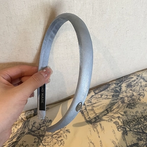 Elegant light blue satin headband with metal detail and handmade label in retro style