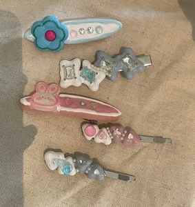 Flat lay of Y2K style resin hair clips with flower, rabbit, and pearl details