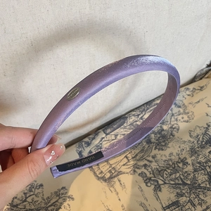 Detail of light purple satin headband showing the handcrafted inner logo tag