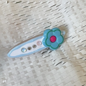 Y2K style light blue acrylic hair clip with flower detail and sparkling rhinestones