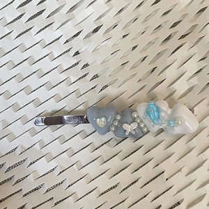 Detailed view of Y2K hair clip with blue resin heart and silver butterfly charm