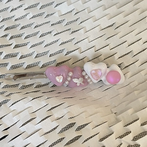 Detail of pink and white enamel heart hair clip with pearls on silver metal base
