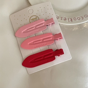 Lot de trois barrettes mates rose et rouge dans un emballage cadeau élégant