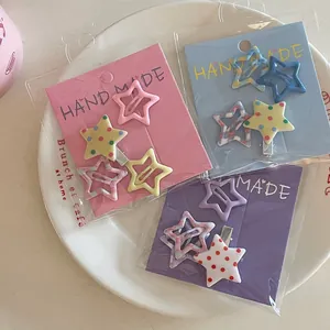 Détail de barrettes en forme d'étoile avec pois et motifs à carreaux sur une assiette