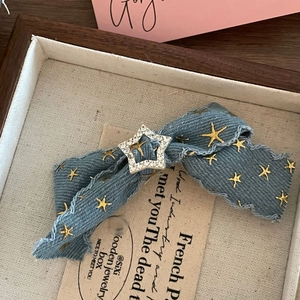 Vintage blue denim bow hair clip with gold star pattern and rhinestone accent