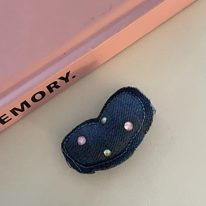 Pince à cheveux Y2K en denim avec strass colorés sur fond minimaliste chaud