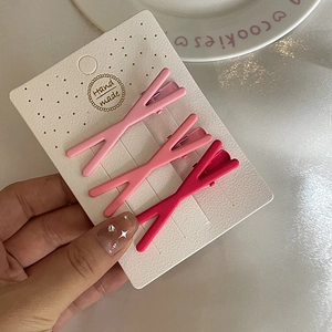 Lot de trois barrettes à cheveux roses mates en forme de nœud sur carte blanche