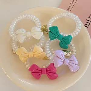Five-piece bow spiral telephone wire hair ties set with metallic charms in soft colors