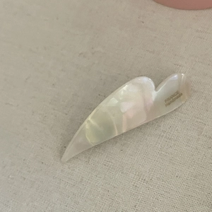 Macro shot of cream acetic acid hair clip with pearl texture and France Handmade text