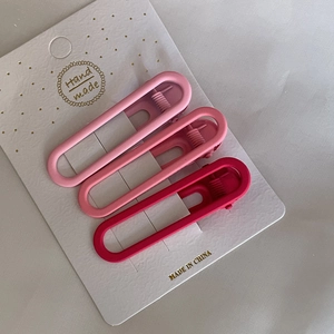 Vue détaillée de trois barrettes rectangulaires roses en dégradé sur carte de présentation