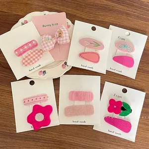 Sets de barrettes roses à fleurs pour enfants avec nœuds sur fond de bois