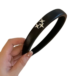 Thick black faux leather headband with sparkling rhinestone star embellishments