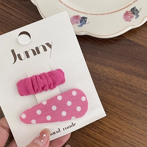 Détail de barrettes à fleurs roses sur une carte faite main avec fond en bois naturel