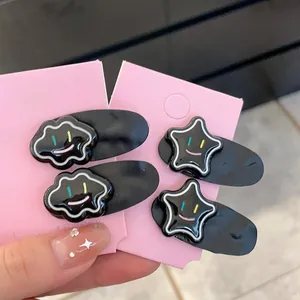Detail of four-piece black resin hair clips featuring cloud and star smiley faces