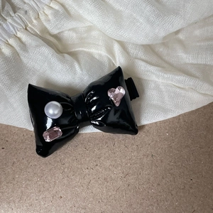 Silver bow hair clip with colorful rhinestones and black patent leather finish for women