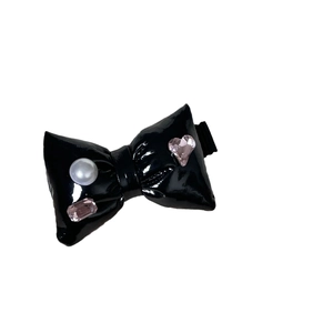 Silver leather bow hair clip with pink rhinestones and a pearl on a black duckbill clip