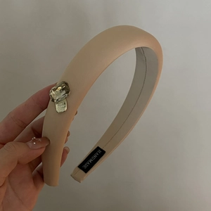 Minimalist pink padded headband with large square rhinestone detail and handmade label