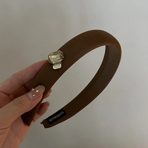 Brown padded sponge headband featuring a single large square crystal on a gold base