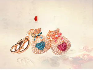 Détail de porte-clés sac de fortune avec strass bleus et roses et mousqueton doré brillant