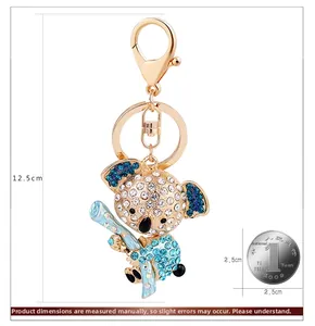 Detailed size comparison of a crystal koala keychain next to a coin for scale