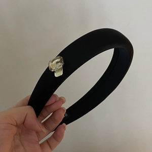 Close-up of padded black sponge headband with a single large rectangular rhinestone