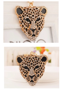 Macro detail of leopard head pendant featuring crystal rhinestones and black enamel accents