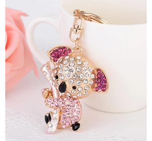 Close-up of sparkling koala keychain with rhinestones hanging on a white ceramic cup