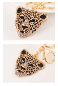Detailed close-up of golden leopard head keychain with sparkling crystal rhinestones