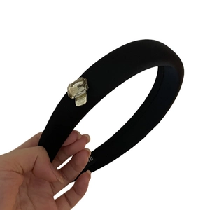 Elegant thick black padded headband featuring a large rectangular rhinestone with gold base