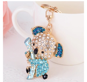 Detailed close-up of a crystal koala keychain with blue rhinestones on a ceramic cup