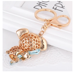 Detail of gold-plated koala keychain featuring hollow-out mesh design and light blue enamel