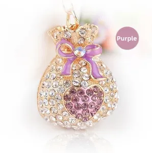 Détail du pendentif sac de fortune avec finition dorée, cristaux violets et nœud chic