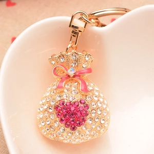 Gros plan détaillé d'un porte-clés sac d'argent en strass rose avec nœud émaillé