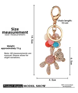 Macro detail of bear keychain with pink and white rhinestones on golden metal base