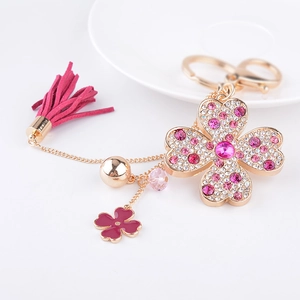 Détail du porte-clés trèfle à quatre feuilles rose avec strass et pompon soyeux
