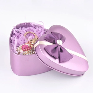 Detail view of heart-shaped gift box with sparkling rhinestone keychain and purple ribbon bow