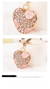 Dettaglio macro del portachiavi a cuore con rosa in smalto rosa e strass di cristallo