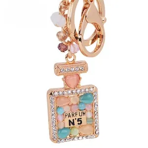 Detail of rose gold perfume bottle keychain with N°5 label and colorful crystals