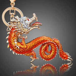 Detailed macro view of golden Chinese dragon keychain with orange enamel and crystals