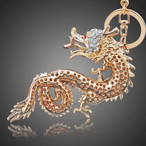 Macro shot of gold dragon keychain with sparkling white rhinestones and red eyes
