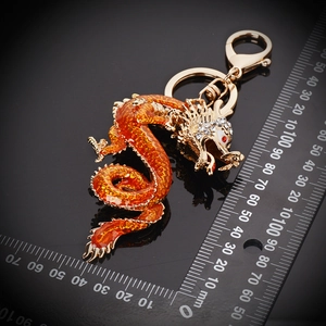 Macro detail of golden dragon keychain with orange enamel and sparkling rhinestones