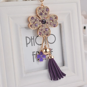 Porte-clés trèfle à quatre feuilles doré avec strass violets et gland en suède