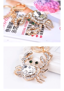 Detailed close-up of golden crab keychain featuring clear crystals and heart-shaped gemstone