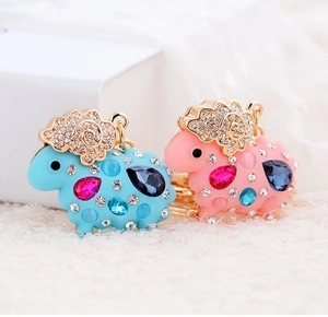 Detailed view of pink and blue resin sheep keychains with crystals and gold-tone metal trim
