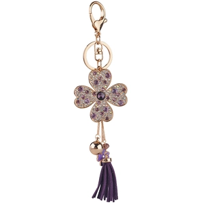 Porte-clés trèfle à quatre feuilles avec strass violets et pompon sur un anneau doré