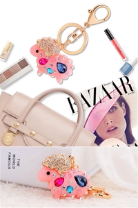 Close-up of pink sheep keychain with colorful crystals and golden lobster clasp detail