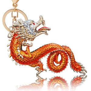 Detail of a golden dragon keychain featuring orange enamel work and white rhinestones