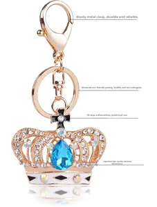 Detail of crystal crown keychain with blue drop gem and polished gold plating